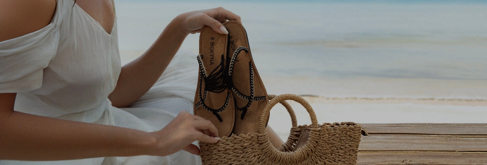 a women handling a pair of sandals - Bokyna sandals
